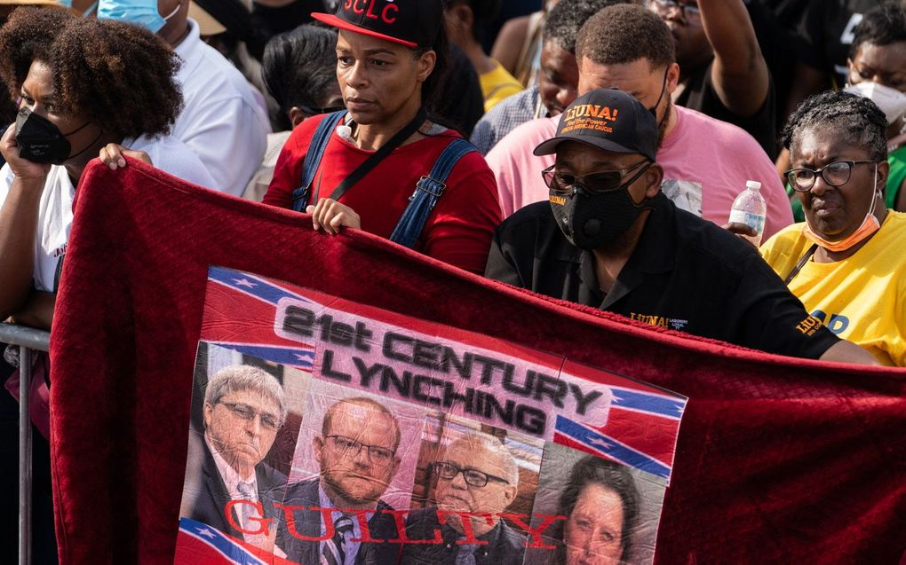 Mensen houden een spandoek omhoog verwijzend naar de moord op Ahmaud Arbery. beeld AFP, Elijah Nouvelage