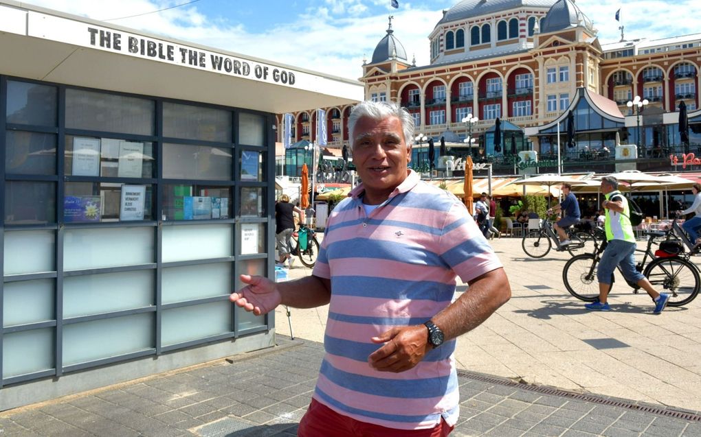 Pieter Voorhoeve (59): „Er lopen hier zo veel mensen die nog nooit van God gehoord hebben. Maar Hij maar één woord nodig.” Op de achtergrond het Kurhaus. beeld Jos van Leeuwen​