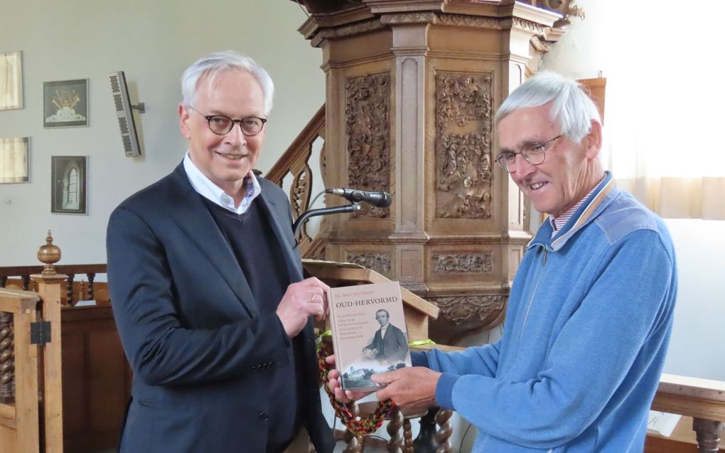 Bart Jan Spruyt (l.) overhandigt –mei dit jaar– zijn boek ”Oud-Hervormd” aan Longerhouwster Sybren Renema. Longhouw was de eerste gemeente van Jan Wouter Felix. Hij begon daar in 1848 als kandidaat. Daarna vertrok hij naar Opheusden. beeld Lijkle Spijksma