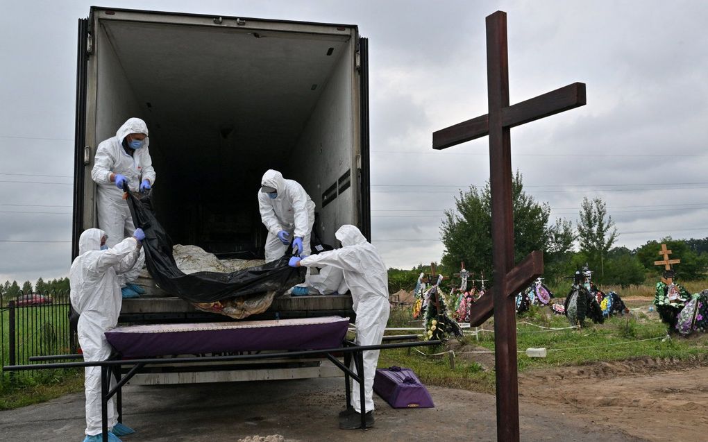 Begrafenis van niet geidentificeerde personen in Boetsja, Oekraine. beeld AFP, Sergei SUPINSKY