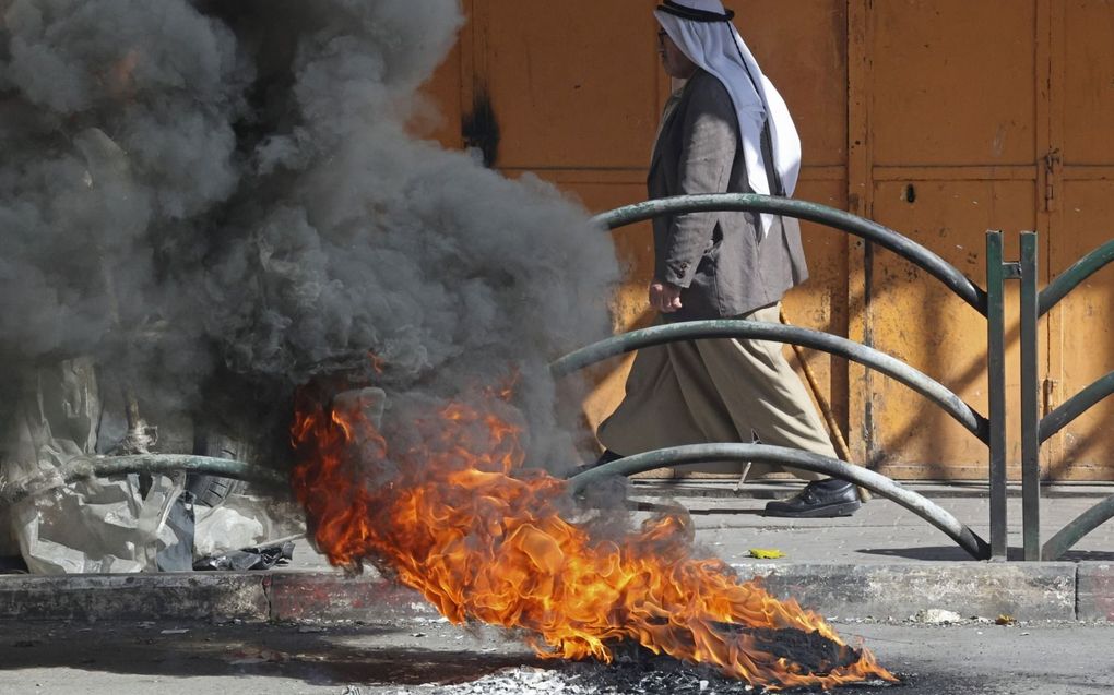 Brandende autobanden als gevolg van rellen op de Westoever. beeld AFP, Hazem Bader