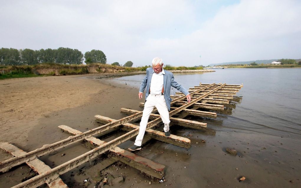 Kobus van Ingen van de uitgeverij van historisch boeken Stichting Tabula Batavorum op de restanten van smalspoor die in de Rijn bij Opheusden boven water zijn gekomen. beeld VidiPhoto