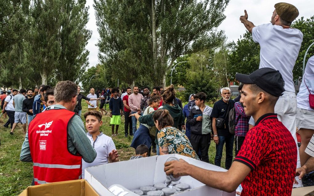 Vrijwilligers deelden vrijdagmiddag bij het aanmeldcentrum in Ter Apel dekens uit aan de honderden asielzoekers die daar in de openlucht bivakkeren. beeld ANP, Vincent Jannink