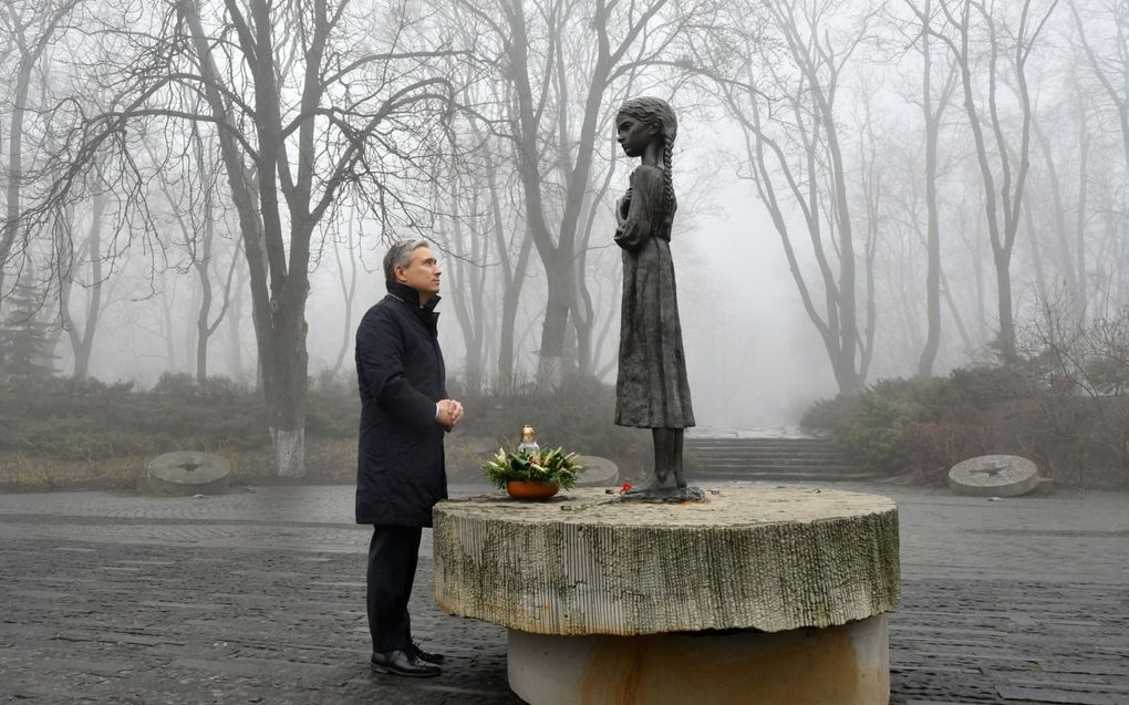 Op een heuvel in Kiev langs de rivier de Dnjepr herinnert het beeld van een klein uitgemergeld mesje met een droevig gezicht aan de hongersnood van 1932 en 1933. Op de foto uit 2020 legt de Canadese minister van Buitenlandse Zaken, François-Philippe Champagne, bloemen bij het monument. beeld AFP, Genja Savilov