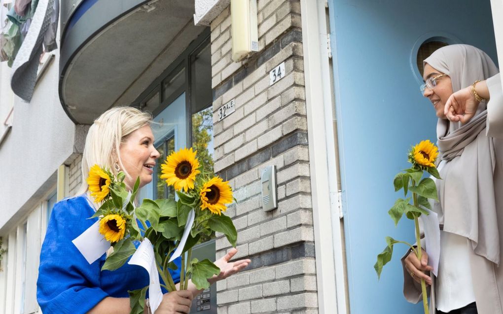 Amal (r.) ontvangt blij verrast een zonnebloem van Marianne de Koning. beeld RD, Anton Dommerholt