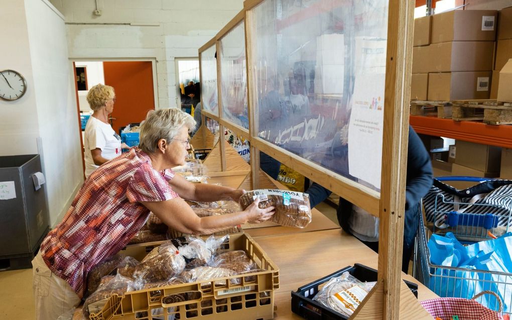 Vrijwilligers reiken etenswaren uit in de voedselbank aan de Amersfoortse Argonweg. De sociale banken zien het aantal cliënten groeien als gevolg van de stijgende kosten van het levensonderhoud. beeld RD, Anton Dommerholt