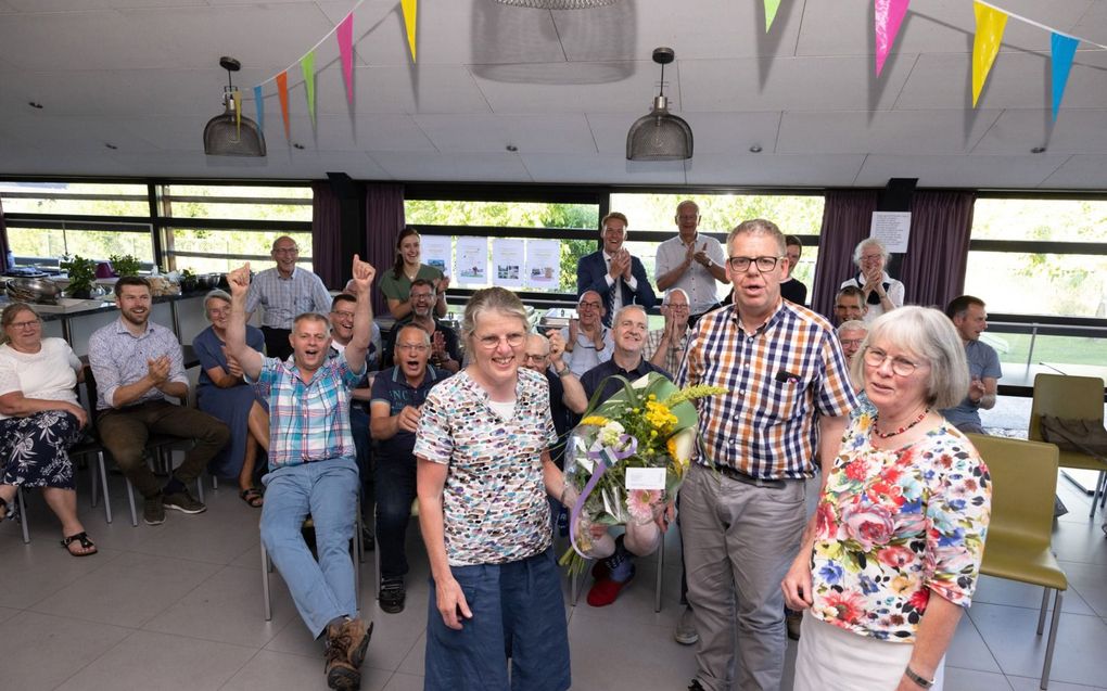 Geertje Ebbers (r.) en vakantiegast Peter Jacobse (m.) geven een bloemetje aan Maatje Pul tijdens een avond die georganiseerd werd ter gelegenheid van het 40-jarig jubileum van Pul als staflid van de VBGG. beeld Dirk Hol