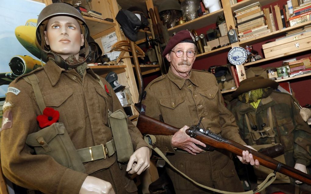 Adriaan van Hemert tussen zijn verzameling. Hij houdt zijn Lee-Enfield geweer in zijn handen. beeld VidiPhoto