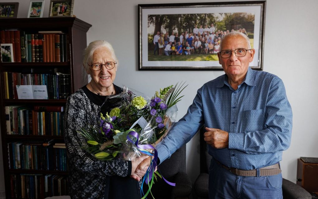 Wichert van Dalfsen (84) uit Genemuiden (r.) geeft buurvrouw Aaltje Timmerman-Kolk (81) een bloemetje om haar te bedanken voor de jarenlange vriendschap. „Ze is altijd belangstellend.” beeld Fotografie Freddy Schinkel