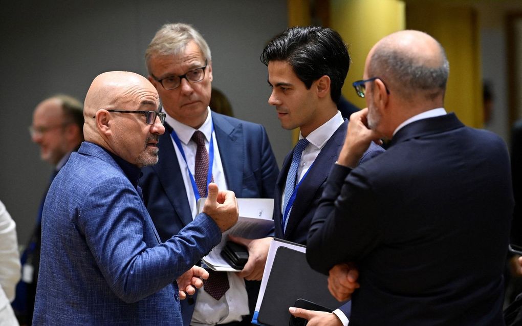 De Italiaanse minister van ecologische transitie Roberto Cingolani (l.) spreekt met de Nederlandse klimaatminister van Klimaat Rob Jetten (tweede rechts) tijdens de opening van een bijeenkomst van de EU-ministers van energie in Brussel. beeld AFP, John Thys