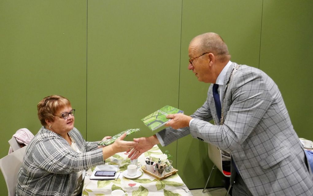 Burgemeester Theo Segers van Molenlanden geeft een cadeau aan Valerie van Kooten uit Pella. beeld Jan van Reenen