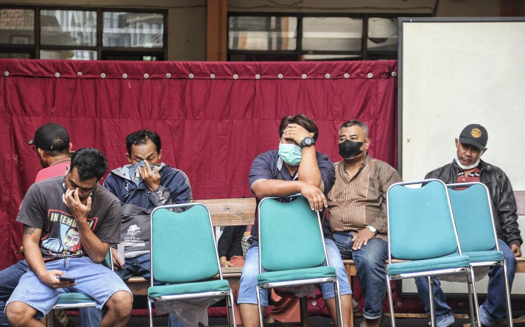 Mensen wachten in de buurt van het stadion op nieuws over familieleden. beeld EPA, SANDI SADEWA