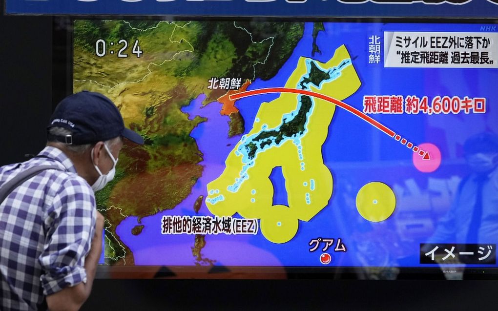 Een voorbijganger in de Japanse stad Tokio kijkt naar nieuws over de raketlancering van Noord-Korea, dinsdag. beeld EPA, Kimimasa Mayama