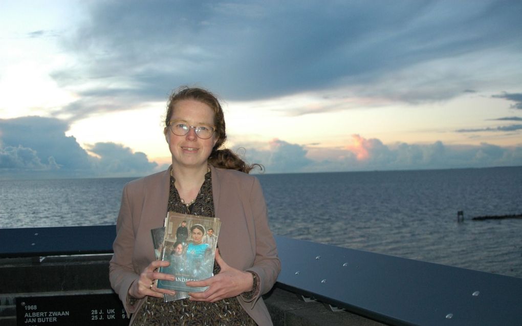 Anita Kramer-Post met haar boek ”Eilandmeisje” bij het vissersmonument. beeld familie Kramer 