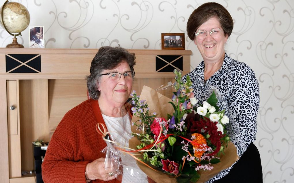 Bep van de Pol-Meyers (l.) geeft bloemetje aan haar vriendin Rianne van der Ham-Labee. „We delen alles met elkaar. Onze vriendschap is enorm waardevol.”