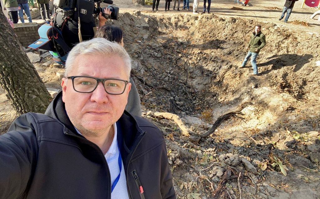 Sergei Nakul bij de krater die een Russische raket maandag sloeg in een speeltuin in Kiev. beeld Sergei Nakul