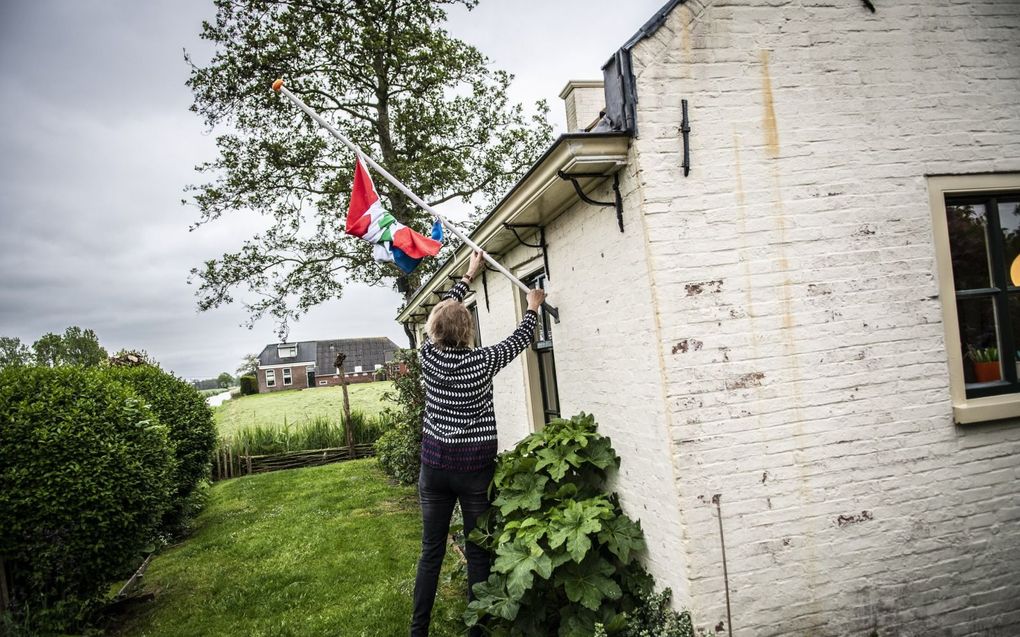 Inwoners van het Groningse Westerwijtwerd hijsen de vlag halfstok na een nieuwe, zware aardbeving in mei 2019. beeld ANP, Anjo de Haan