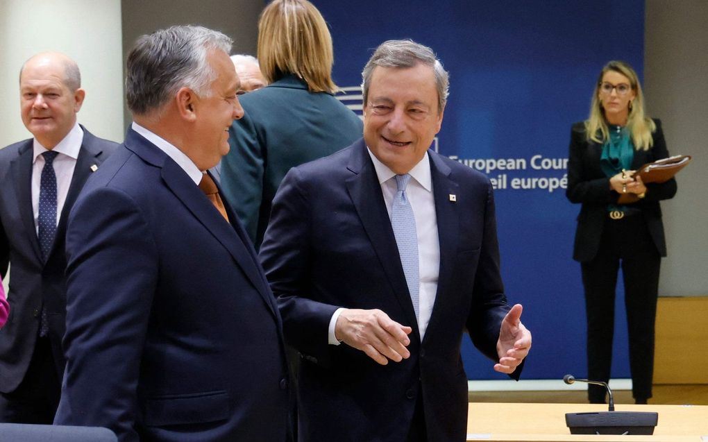 De Hongaarse premier Viktor Orban en de Italiaanse premier Mario Draghi spreken samen voorafgaand aan een top van de EU-leiders in het gebouw van de Europese Raad in Brussel. beeld AFP, Ludovic Marin