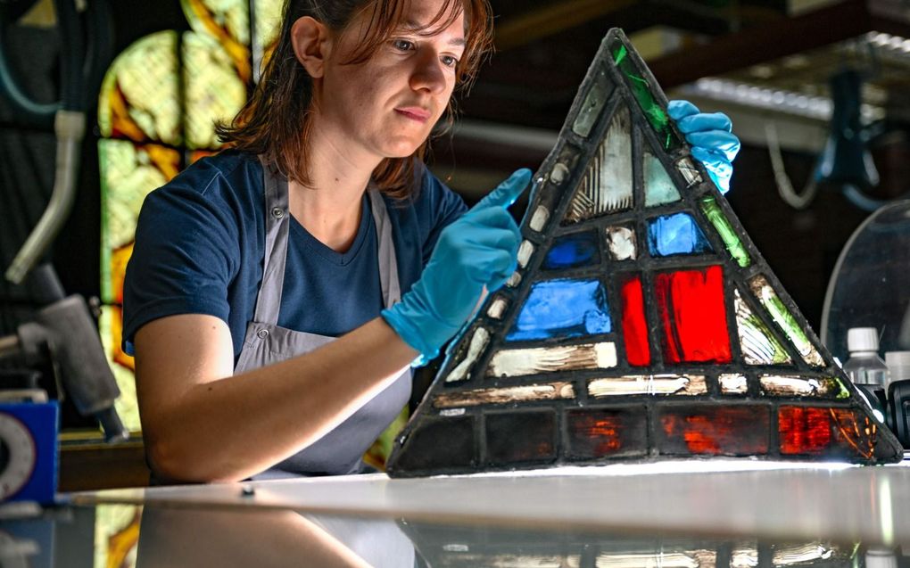 Medewerker Elodie Schneider van het Duitse bedrijf Dombauhütte Köln restaureert een glas-in-loodraam van de Notre Dame in Parijs. De kathedraal raakte in april 2019 ernstig beschadigd bij een grote brand. Dombauhütte Köln voert normaalgesproken renovatiewerkzaamheden uit aan de dom van Keulen. beeld AFP, Sascha Schuermann