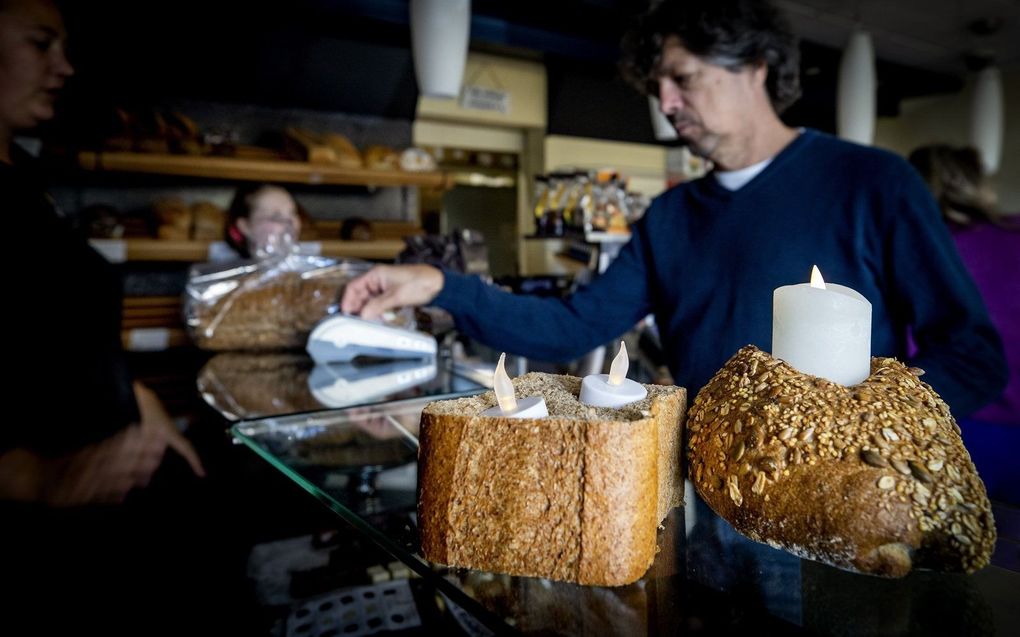 Een bakker in Bussum laat het licht in zijn zaak uit uit protest tegen de energiecompensatieregeling van het kabinet. beeld ANP, Koen van Weel