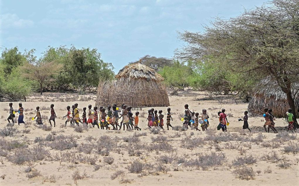 Kinderen op weg naar een voedseluitdeelpunt in Nadoto, Kenia. beeld AFP, Tony Karumba