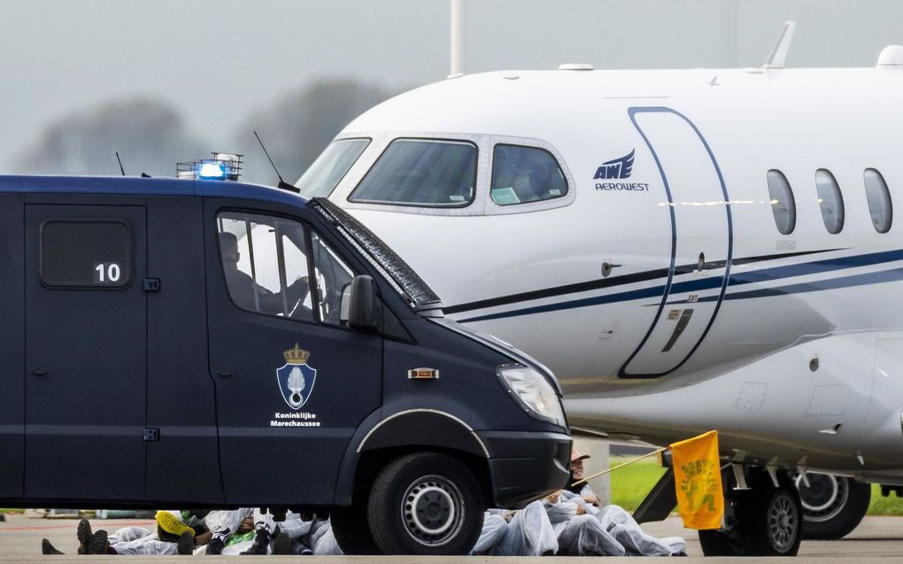 De Marechaussee arresteert klimaatactivisten op Schiphol. beeld ANP, Remko de Waal