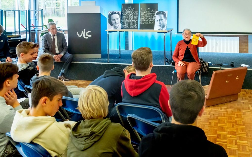 De Litouwse en Nederlandse leerlingen luisteren op het Van Lodenstein College naar het verhaal van gastspreker Greta Cune. Op de achtergrond de foto’s van de ouders van Cune. beeld Ruben Schipper