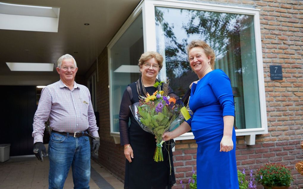 Corrie van ’t Foort-Hardeman (l.) krijgt bloemen van haar dochter Jannie van Veldhuizen-van ’t Foort. „Je kunt altijd bij mijn moeder terecht.” Op de achtergrond staat de echtgenoot van Van ’t Foort. beeld Jaco Klamer