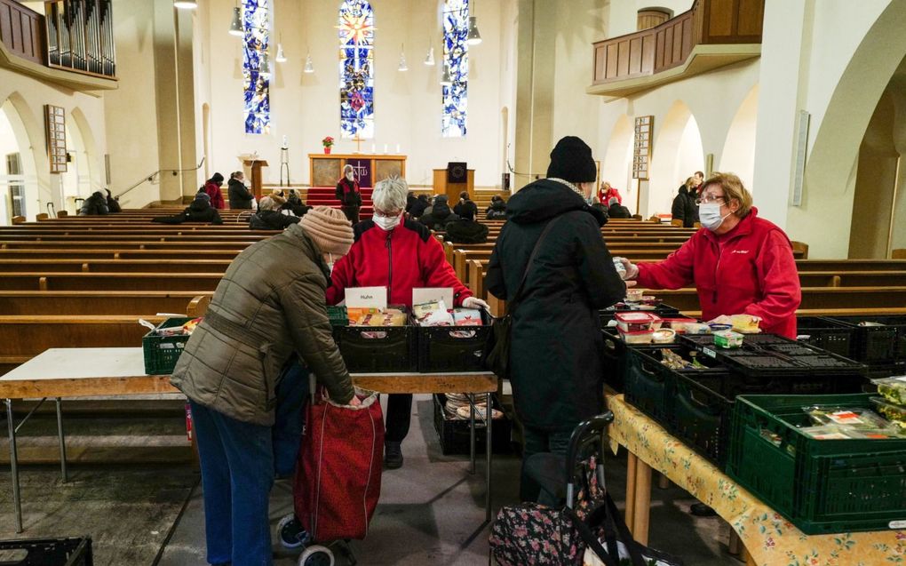 De voedseluitdeelpunten van Berliner Tafel (Berlijnse tafel), zoals in een protestantse kerk in Berlijn, trekken veel mensen. De organisatie Berliner Tafel haalt onverkocht voedsel op bij supermarkten en bakkerijen, sorteert het in haar magazijnen en verdeelt het opnieuw over sociale programma’s en verschillende voedselbedelingspunten. De Berliner Tafel bereikt maandelijks meer dan 165.000 mensen. beeld EPA, Filip Zanger