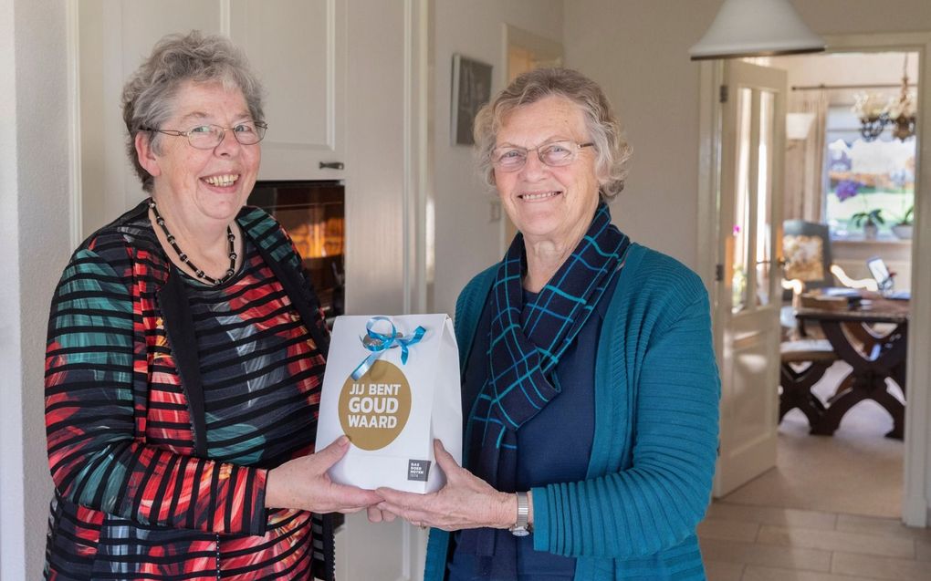 Marry de Kruijf-Van Woudenberg (r.) uit Waarder geeft een notenpakket aan haar schoonzus Dicky de Kruijf-Kok uit Berkhoven. „Dicky staat altijd klaar voor haar tante Riek. Dat verdient respect.” beeld Erik Kottier