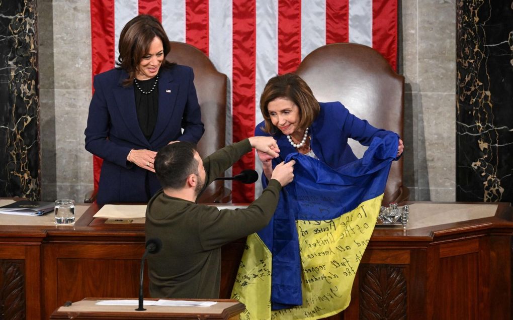 De Oekraïense Volodimir Zelenski overhandigde woensdag tijdens zijn bezoek aan Washington de vlag van zijn land aan Nancy Pelosi, de voorzitter van het Huis van Afgevaardigden. Op de vlag hadden frontsoldaten hun handtekening gezet om Amerika te danken voor de wapensteun. Links de Amerikaanse vicepresident Kamala Harris. beeld AFP, Mandel Ngan