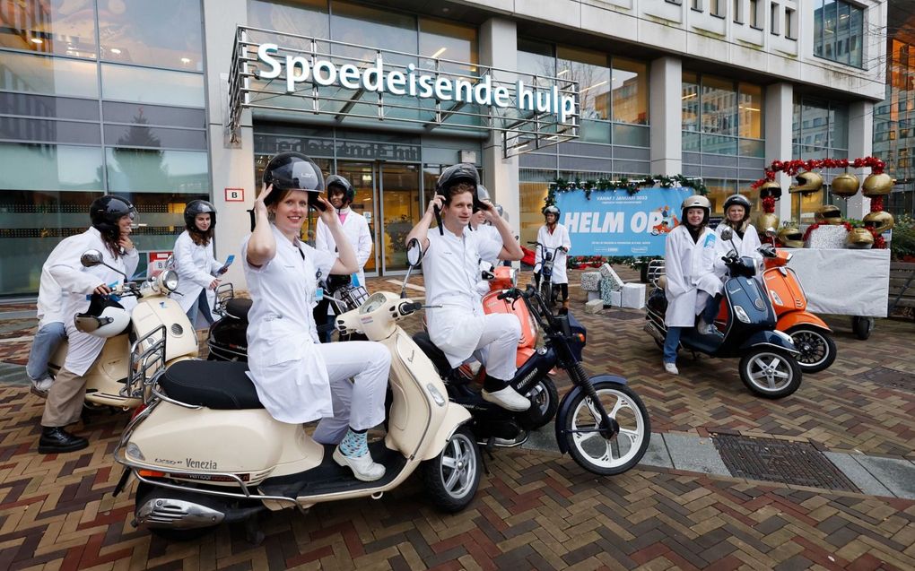 Artsen van het Erasmus MC en leden van jongerenorganisatie TeamAlert op 5 december in Rotterdam tijdens de aftrap van de voorlichtingscampagne over de naderende helmplicht voor snorfietsers. beeld ANP, Bas Czerwinski