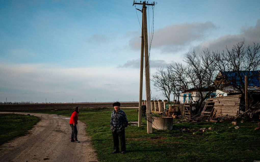 Familie bij hun woning zonder water en elektriciteit in de regio Cherson. Beeld AFP, Dimitar DILKOFF