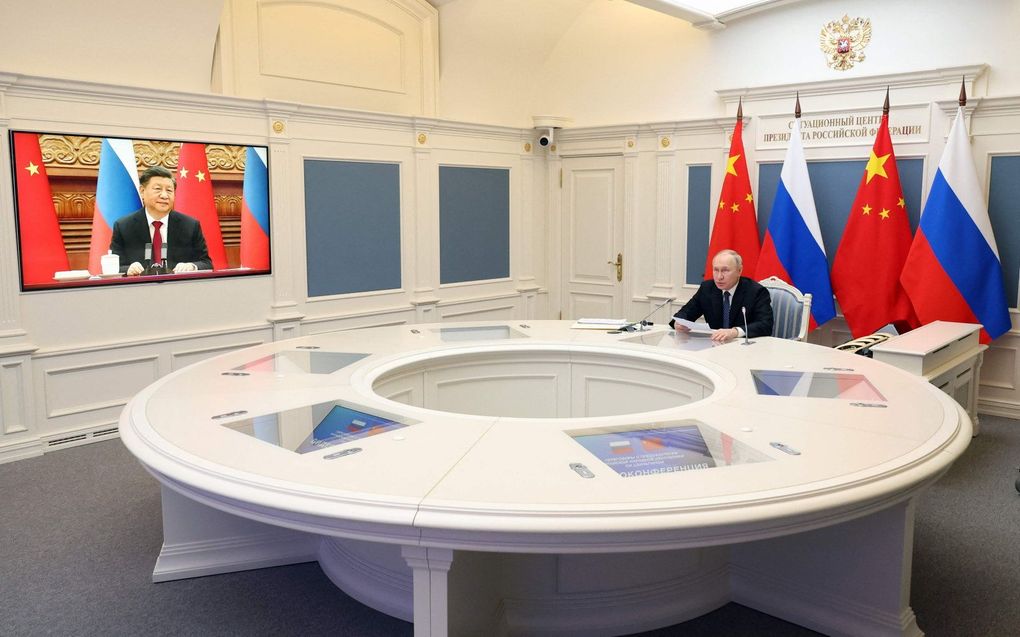 De Russische president Vladimir Poetin tijdens een videogesprek met de Chinese president Xi Jinping. beeld AFP / Sputnik