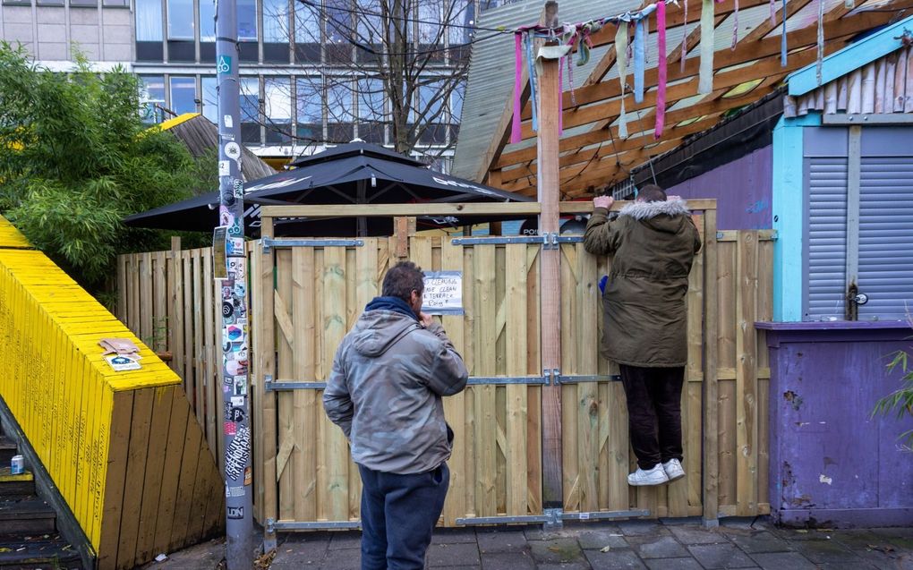 Rafal spiekt over een hek bij de Biergarten in Rotterdam. beeld Roel Dijkstra Fotografie