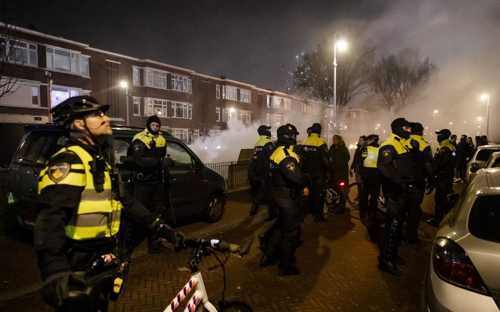 Leden van de Mobiele Eenheid beschermen de brandweer tijdens de jaarwisseling in Den Haag. beeld ANP, Sem van de Wal