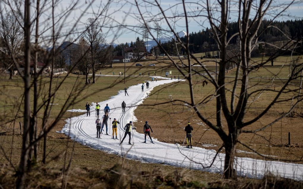 Langlaufers banen zich een weg op een piste in een verder sneeuwloze omgeving in Ramsau am Dachstein, Oostenrijk. Landen in heel Europa hebben volgens meteorologen te maken gehad met recordhoge temperaturen in januari. Ten minste acht Europese landen hebben hun warmste januaridagen ooit gemeten.  beeld EPA, Christian Bruna