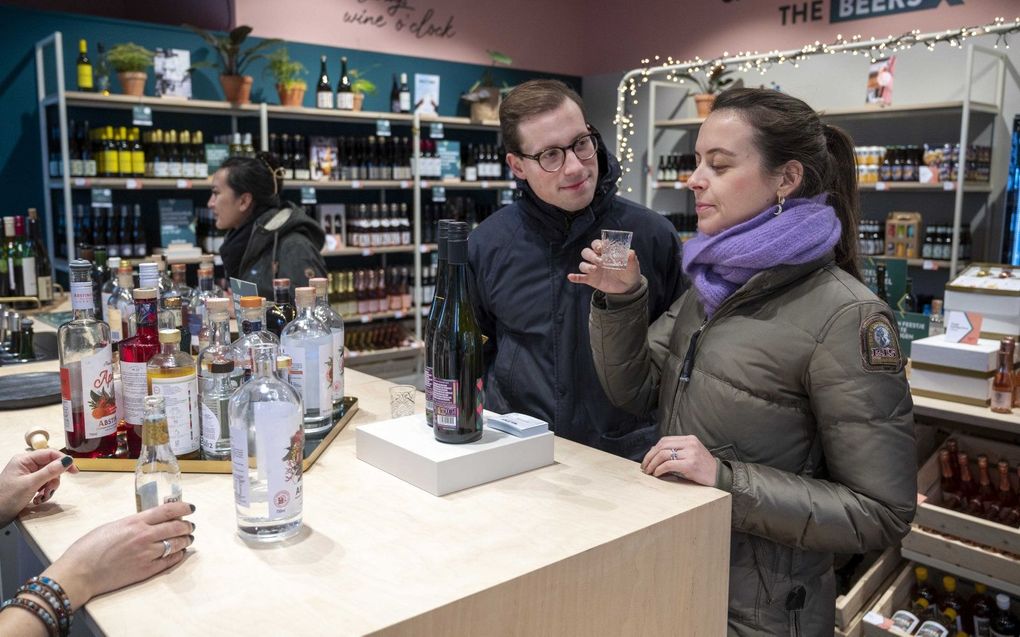 Klanten mogen even proeven in een alcoholvrije slijterij, ter gelegenheid van Dry January, een initiatief om alcoholgebruik te matigen. beeld ANP, Evert Elzing