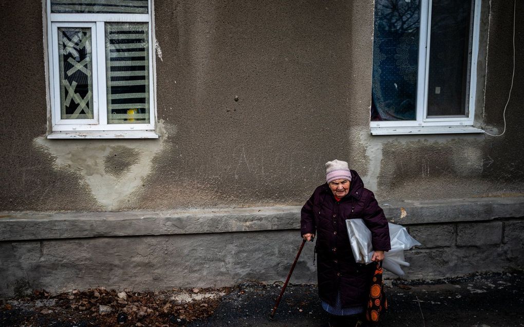 Een vrouw repareert haar ramen in het oosten van Oekraine. beeld AFP, Dimitar DILKOFF