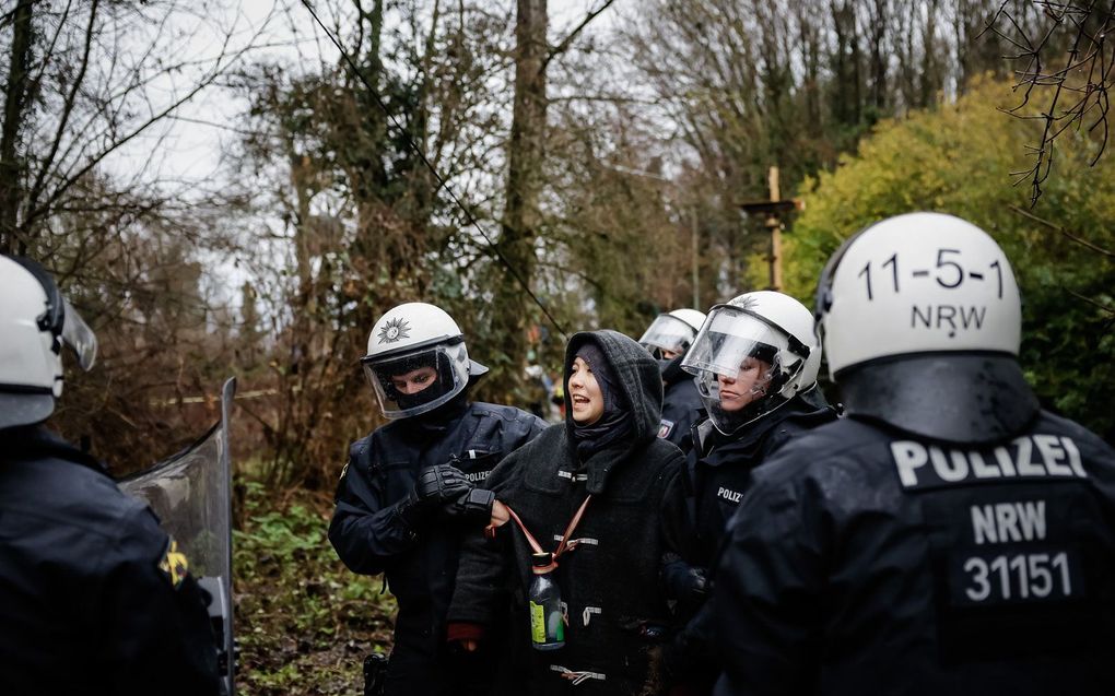 Politieagenten tijdens een confrontatie met klimaatactivisten, tijdens de ontruiming van Lutzerath. beeld ANP, Robin van Lonkhuijsen