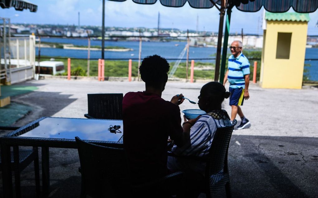 Ziekenverzorgende Eldrick Diaz​ geeft een bewoner van verzorgingstehuis Kas Hugenholtz in Willemstad te eten. beeld Maarten Boersema