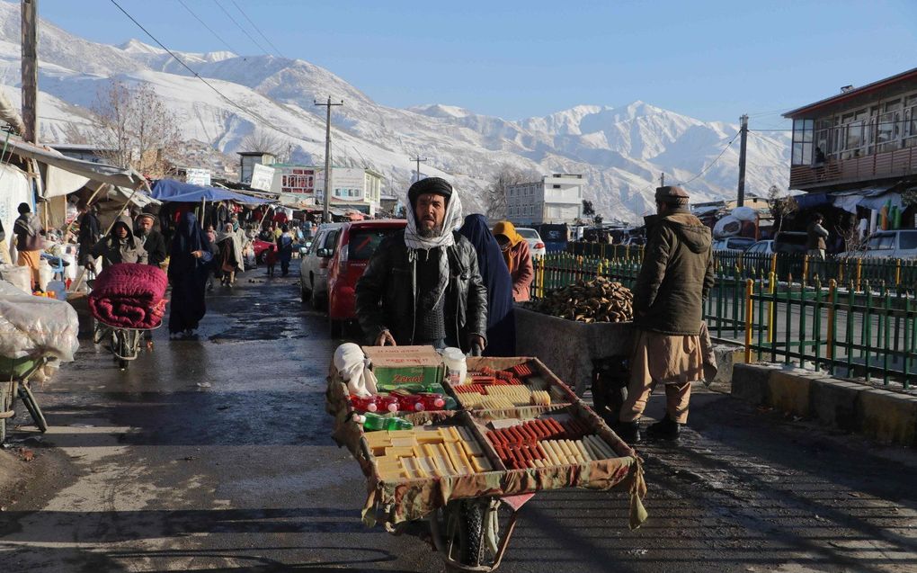 Een handelaar in de Afghaanse stad Fayzabad trotseert de koude. beeld AFP, Omer Abrar