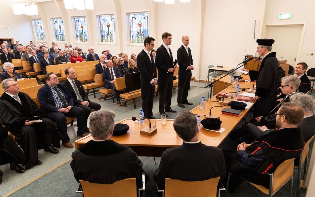 In de aula van de Theologische Universiteit Apeldoorn verdedigde Jan Kees Kooijman maandagmiddag zijn proefschrift ”Eén kudde, één Herder”. De missioloog van Zending Gereformeerde Gemeenten deed onderzoek naar de uitleg van Johannes 10:16 in de Vroege Kerk. Kooijman kreeg zijn doctorsbul overhandigd door prof. dr. M.A. van Willigen. Paranimfen waren Dirk-Jan Nijsink (l.) en Just van Toor (r.).  beeld RD, Anton Dommerholt