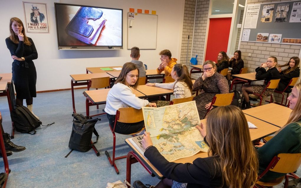 In gesprek over de watersnood. Linde toont de kaart aan de klas. Op de achtergrond het Bijbeltje van Paulientje. beeld Dirk-Jan Gjeltema