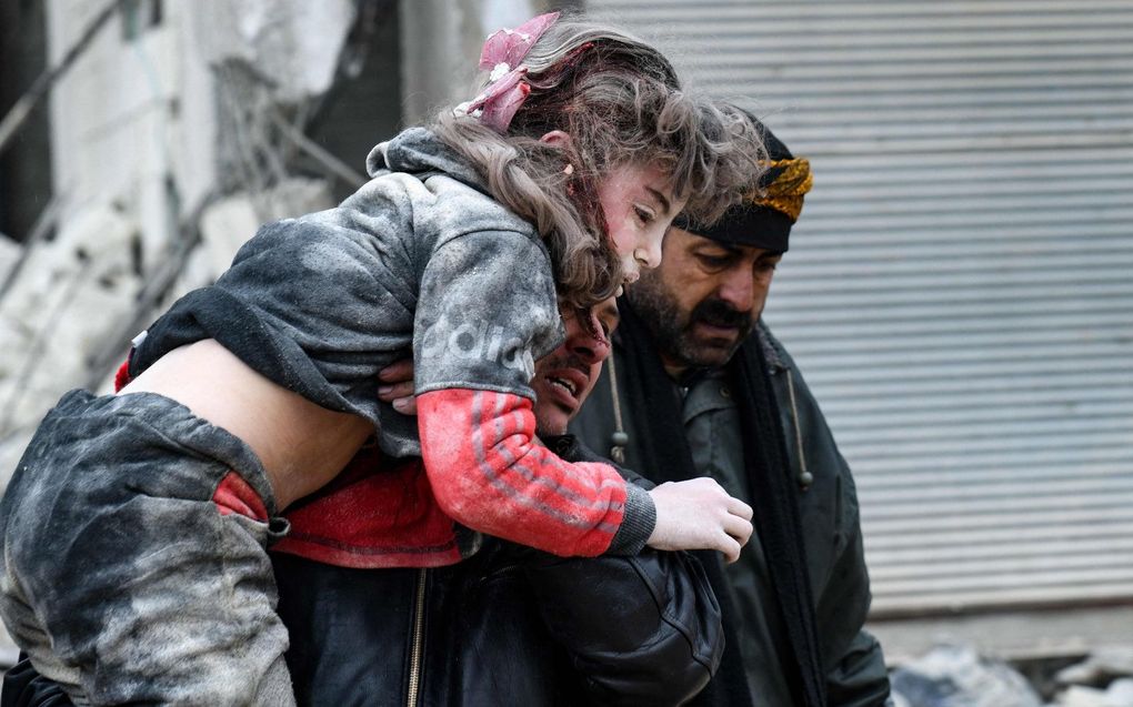 Omwonenden dragen een gewond kind uit het puin van een ingestort gebouw in de Syrische plaats Jandaris, bij de stad Afrin. beeld AFP, Rami al SAYED