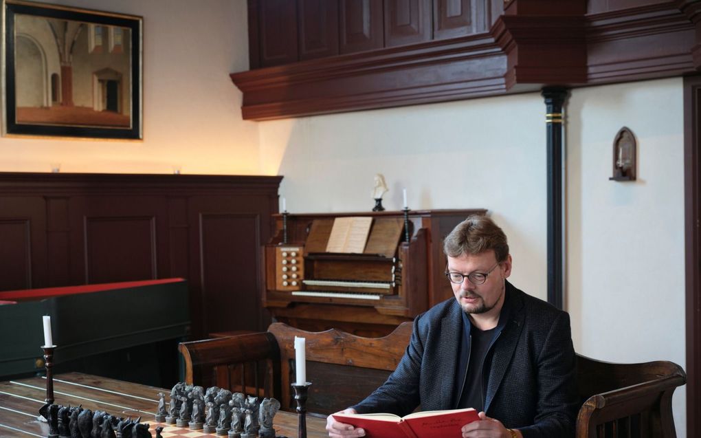 Sietze de Vries aan tafel in zijn Kerkhuis naast zijn woning in Niezijl. De Groningse organist improviseerde de afgelopen tijd over 45 liederen waarvan Bach in zijn Orgelbüchlein wel de titel van noteerde, maar er geen bewerking over schreef. beeld Sjaak Verboom