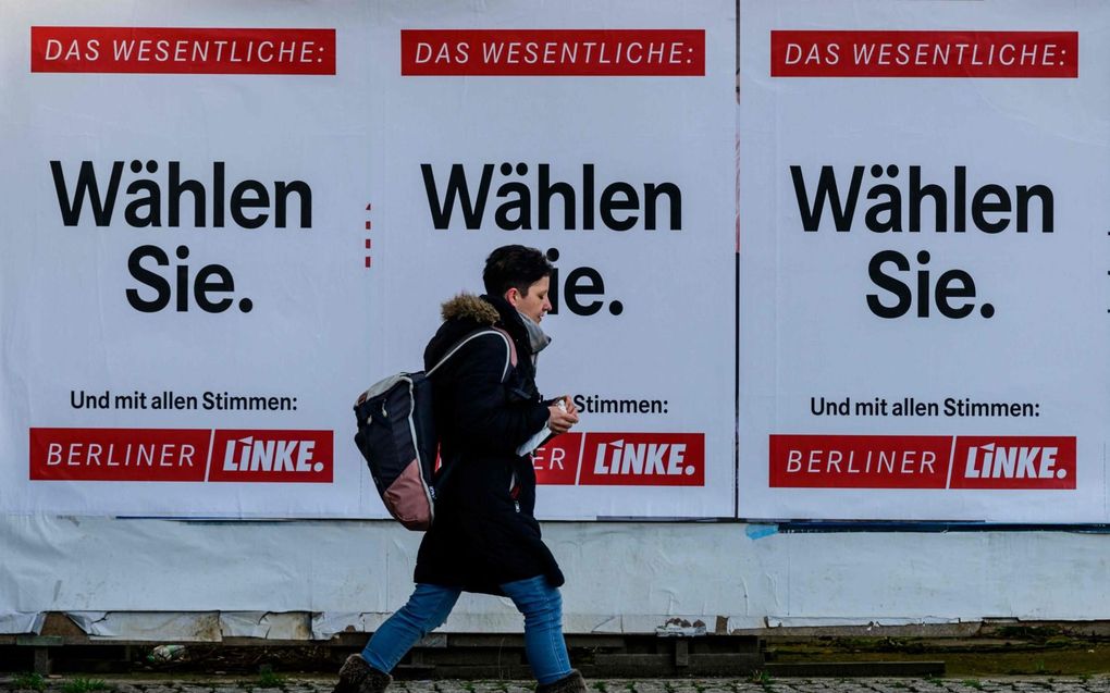 De inwoners van Berlijn mogen zondag opnieuw naar de stembus. Op de foto loopt een inwoner van Berlijn langs een verkiezingsaffiche van Die Linke, de opvolger van de vroegere communistische partij van Oost-Duitsland. beeld AFP, John MacDougall