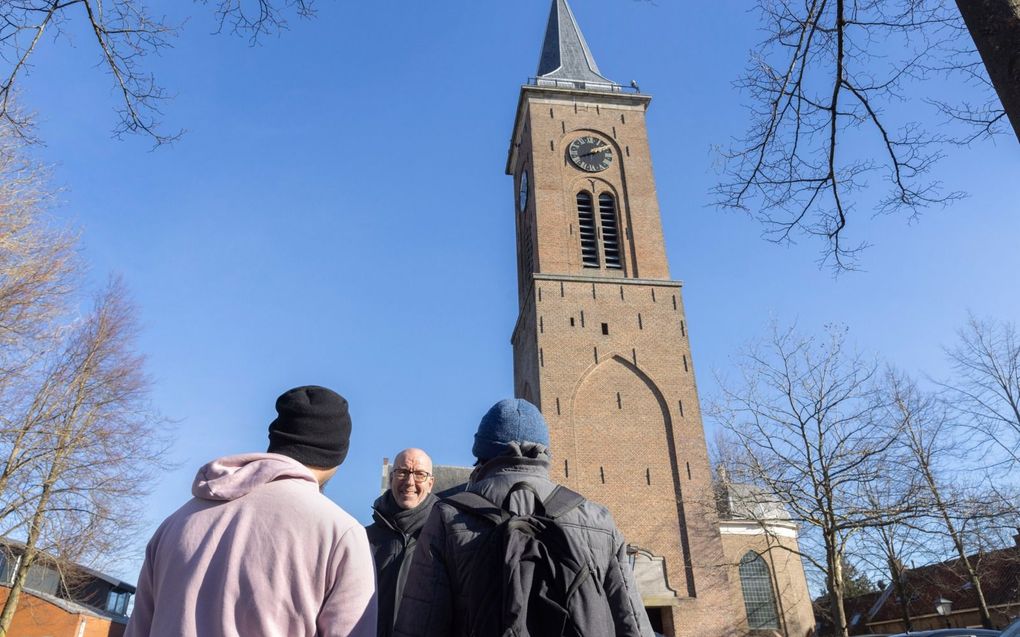 Vrijwilliger Tom Eek in gesprek met enkele statushouders die tijdelijk in de pastorie bij de Pieterskerk in Breukelen wonen. beeld Erik Kottier