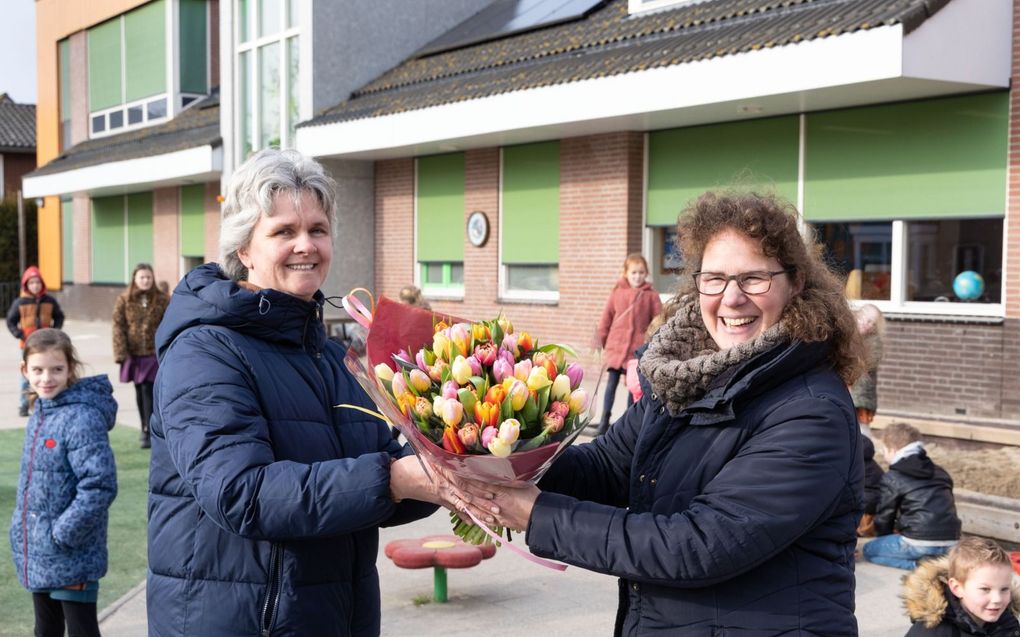 Petra van Oudenaarden-van Dijk (r.) overhandigt Carola Oskam-Hoogvliet een bos tulpen. „Ze is er, ze coördineert en is oplossingsgericht.”