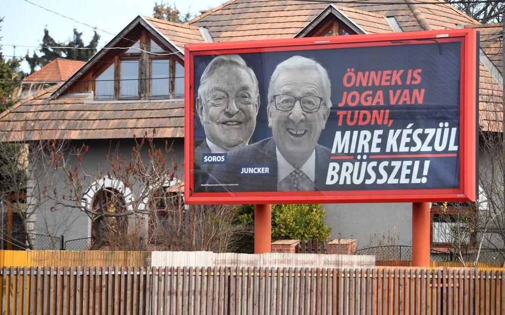 Billboard van campagne tegen Soros (l.) en Juncker (r.) in 2019 in Hongarije. beeld AFP, Attila Kisbenedek